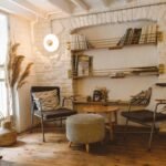 Inviting modern rustic living room featuring armchairs, an ottoman, and a stylish bookshelf.